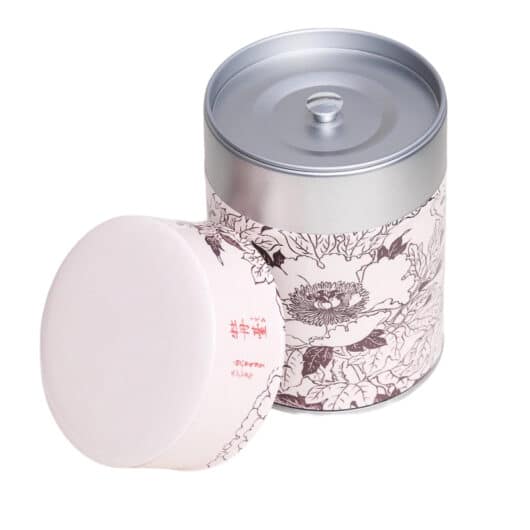 Metal tea caddy illustrated with a design of Japanese flowers with Japanese characters on a pink/beige background - open caddy